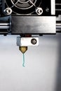 3D printer nozzle and green plastic closeup