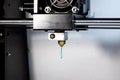 3D printer nozzle and green plastic closeup Royalty Free Stock Photo