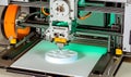 3 d printer in operation creating a white circular object close up Royalty Free Stock Photo