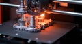 A 3D printer in operation, fabricating gear-like structures. The scene is lit with a warm Royalty Free Stock Photo