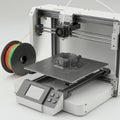 3D printer in operation, featuring a partially completed object on the printing bed. The Royalty Free Stock Photo