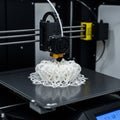 A 3D printer in operation, producing a complex, heart-shaped lattice structure