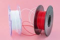 3D Printer Plastic Filament. Spool of white and red thermoplastic wire for 3D printing close up Royalty Free Stock Photo