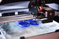 The 3D printer prints the details of the blue plastic.