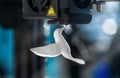 The 3D printer prints white plastic model of hummingbird