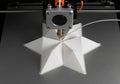 A 3D printer is in the process of printing a geometric white star-shaped Royalty Free Stock Photo