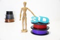 3D printing filament reels with wooden anthropomorphic doll with text `3d` on white background