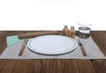 Empty plate on wooden table. Salt, pepper, serviette, glass of water and wooden cutlery. Isolated on white background. Royalty Free Stock Photo