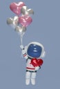 3D render An astronaut holds several heart-shaped balloons. Cartoon character astronaut floating in space with red tiny hearts. 3d