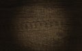 3D render of dark brown wooden plank texture with spot light on center, top view