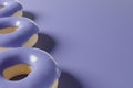 3d render of donut pattern with violet glaze on a purple background