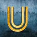 3D render of a golden letter U on the backdrop of a weathered blue surface