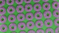 3D render of a large number of donuts on a green table background