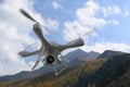 3d render quadrocopters mountains in the background. Radio-controlled drone is filming nature. Unmanned flying toys Royalty Free Stock Photo