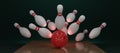 3d render a red bowling ball crashing into the pins on a dark green background. Bowling ball striking against pins. Concept of Royalty Free Stock Photo