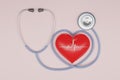 3D render red heart with a medical stethoscope isolate on pink background. Blood pressure control. Heart and heartbeat. Healthcare