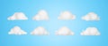 3D render of set isolated white cartoon clouds on blue background. Royalty Free Stock Photo