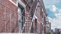 3D render of a staircase leading upward adjacent to the red brick building .