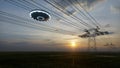 3d render. UFO over the field and high-voltage power lines Royalty Free Stock Photo