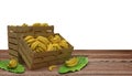 Wooden crates or boxes full of bananas place on wooden table. And banana leaf next to. Isolated on White.