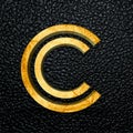3D rendered golden letter C against a black leather background