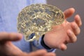 3D rendered hologram of a brain hovering over a real personÃ¢â¬â¢s hands