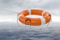 3D rendered illustration of orange life buoy. Sea in background Royalty Free Stock Photo