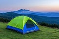 A 3D-rendered image of a camping tent in a mountain meadow at sunset. Royalty Free Stock Photo