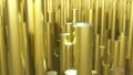 3d rendering of abstract gold metallic cylinders with floating orange embers in background and bokeh