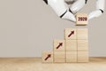 3d rendering artificial intelligence robot hand flip the 2020 wooden cube concept to make growth in business in year 2020