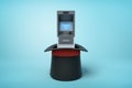 3d rendering of ATM standing in black top hat which is standing upside down on light-blue background. Royalty Free Stock Photo