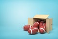 3d rendering of balls for American football inside and in front of cardboard box on light-blue background.