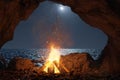 3d rendering of big bonfire with sparks and particles in front of sea and cave