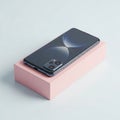 A sleek black smartphone on a pink display block Royalty Free Stock Photo