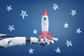 3d rendering of black and white robotic arm holds a small retro rocket on its palm on a background with chalk stars.