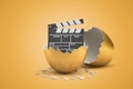 3d rendering of broken golden eggshell with movie clapper inside on yellow background