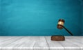 3d rendering of a brown wooden judge gavel and sound block lying on a wooden table against blue background.