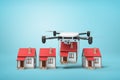 3d rendering of camera drone carrying small cottage and putting it down in a row with other 3 identic cottages on light