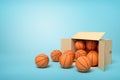 3d rendering of cardboard box lying sidelong full of basketballs on light-blue background.