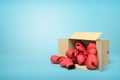 3d rendering of cardboard box lying sidelong full of red boxing gloves on light-blue background with much copy space. Royalty Free Stock Photo