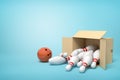 3d rendering of cardboard box lying sidelong full of white bowling pins and one brown bowling ball next to it on light