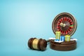 3d rendering of casino roulette, chips and playing cards on round wooden block and brown wooden gavel on blue background Royalty Free Stock Photo