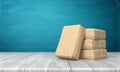 3d rendering of a cement bag leaning over three other stacked packs on a wooden table on blue background.