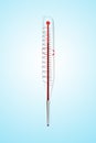 A clinical thermometer against blue backgraound