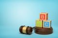 3d rendering of colorful alphabet toy blocks on round wooden block and brown wooden gavel on blue background Royalty Free Stock Photo