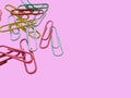 Colourful paperclips on a pink background. 3d rendering.