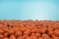 3d rendering of endless pile of orange basketball balls with black stripes lying in heap on a blue background.