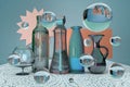 3d rendering of fantastical futuristic glass still life with bottle, jar, vase, wine glass and bubbles on lace tablecloth