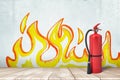 3d rendering of a fire extinguisher standing at the wall with the drawing of flames on it. Royalty Free Stock Photo