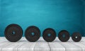 3d rendering of five black weight plates on white wooden floor and dark turquoise background